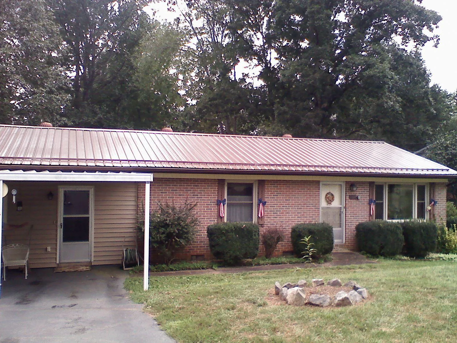 Bronze metal roof and carport on a brick ranch home — Roof Repair work by our crew in Roanoke